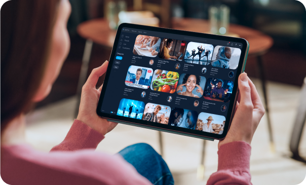 A person holding a tablet displaying a variety of video content and ads, reflecting Signa Marketing's expertise in creating visually appealing paid social advertising campaigns that resonate with audiences on platforms like Facebook, Instagram, and LinkedIn.