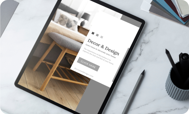 Tablet displaying a modern web page with a focus on decor and design, placed on a marble desk alongside a pen, paper stack, and a cup of pencils. This image reflects Signa Marketing's Web Development services, highlighting their ability to create visually appealing, functional, and performance-optimized websites that provide exceptional user experiences and measurable results.