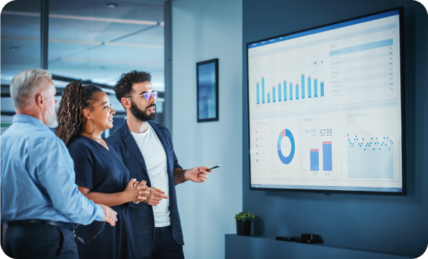 A team of professionals at Signa Marketing reviewing data visualizations on a large screen, including charts and graphs. The visuals emphasize the importance of data-driven strategies in optimizing local SEO to increase business visibility and customer reach.